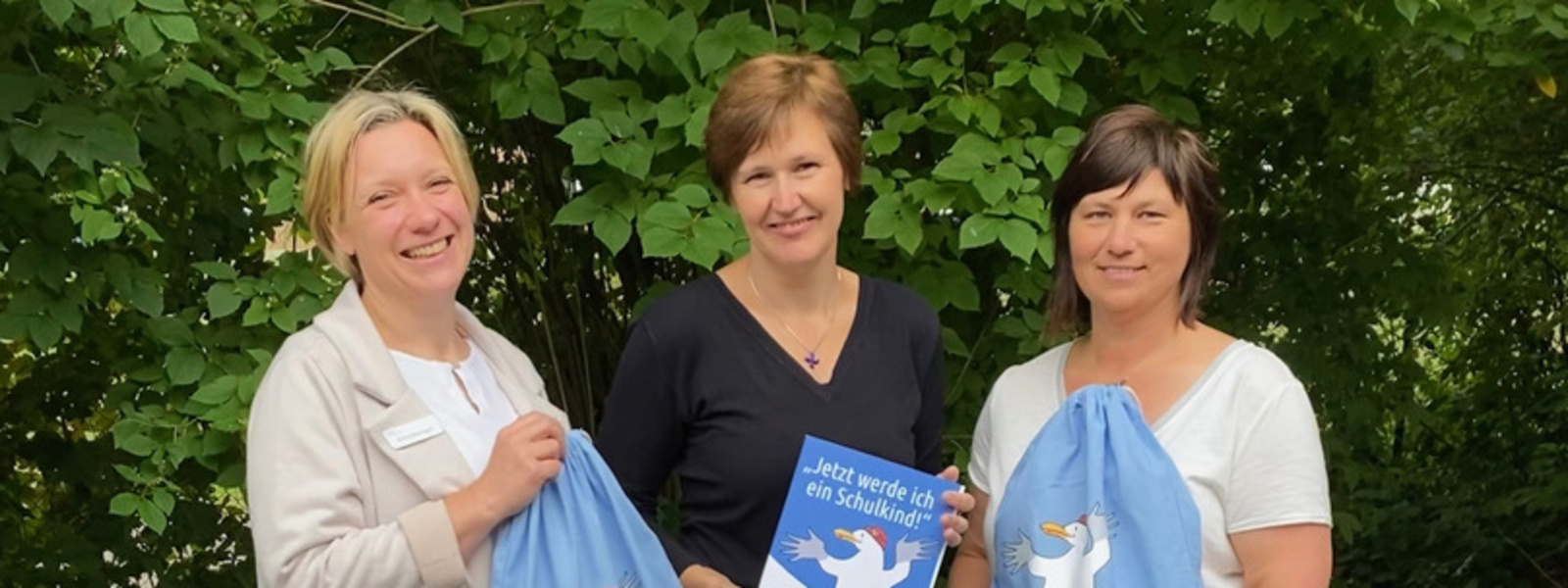 die drei Koordinatorinnen des Projektes "Jetzt werde ich ein Schulkind" Britta Baumgart, Petra Busemann und Jana Borowski präsentieren die Rucksäcke und das Arbeitsheft